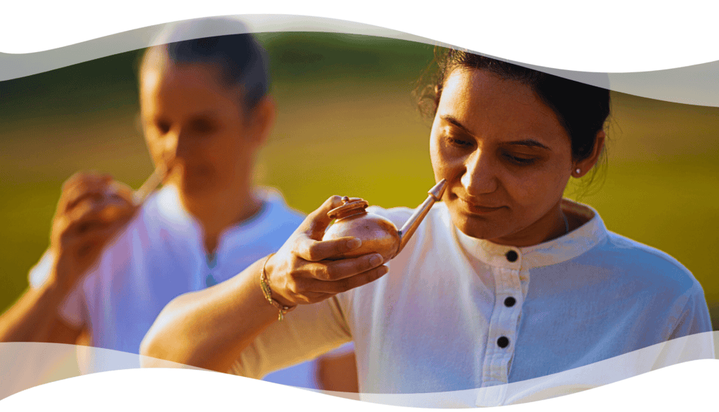 Participants practicing Jala Neti using copper pots during a classical Hatha Yoga cleansing session outdoors