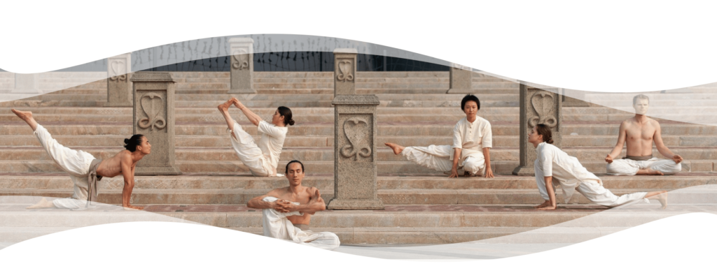 Group of Hatha Yoga practitioners in white clothing performing asanas and meditation on stone steps with carved pillars.